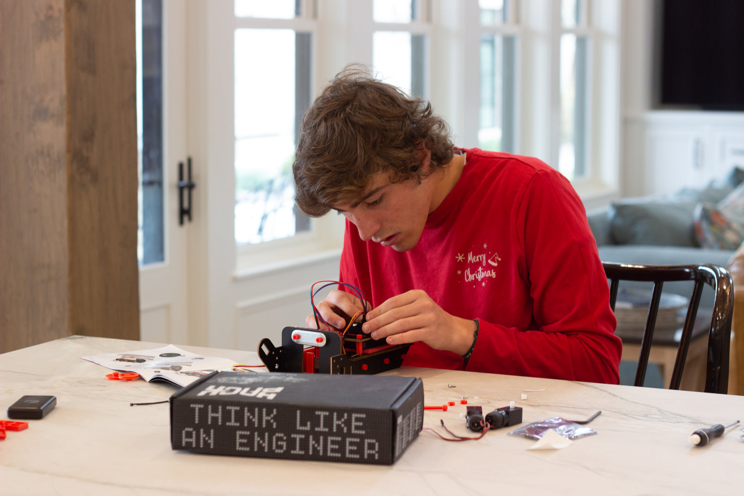 Photo of a Teen Boy Assembling an Hack Pack Robot